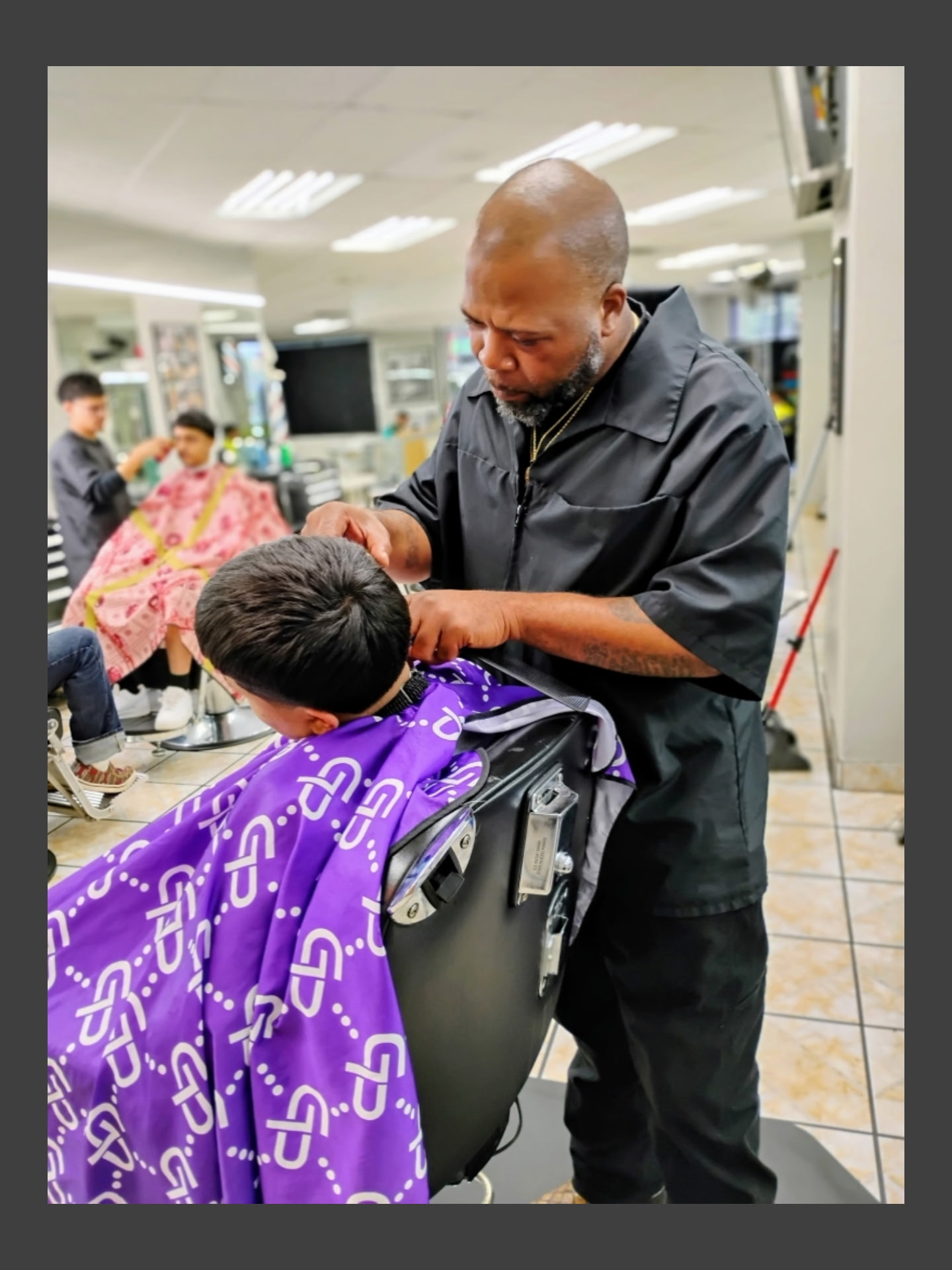 A barber working with a client at Mid Cities Barber College